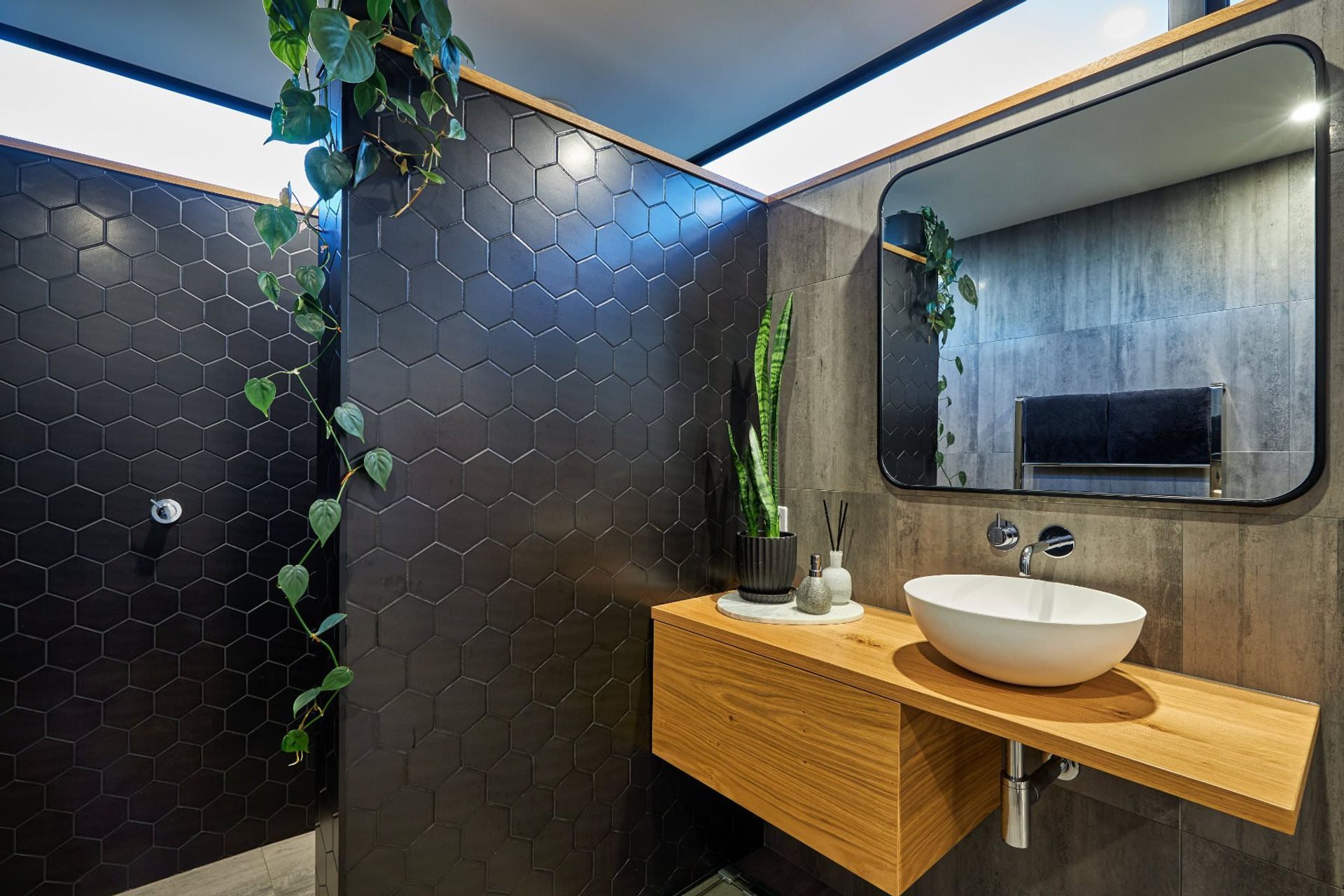 A strategically placed climbing plant and well poised pot plant are inviting additions to this Hapuku home bathroom — Photography: Andrew Spencer