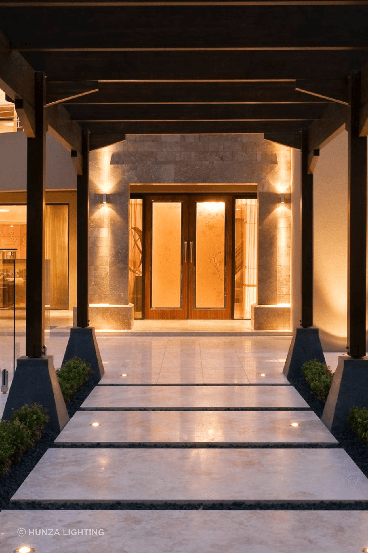 Outdoor pillar lights keep the entrance to this house well lit, while the walkway lights highlight the garden beds.