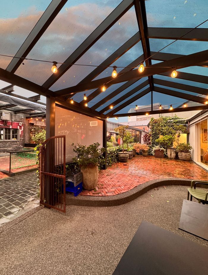The acrylic roof on this pergola allows it to be used in any weather and the custom tinting gives protection from the sun.