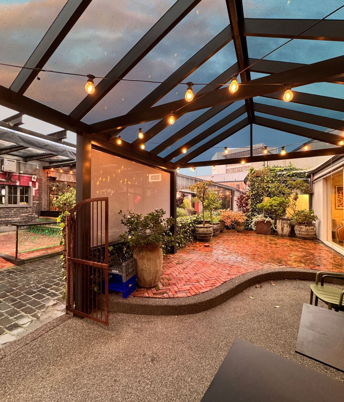 The acrylic roof on this pergola allows it to be used in any weather and the custom tinting gives protection from the sun.