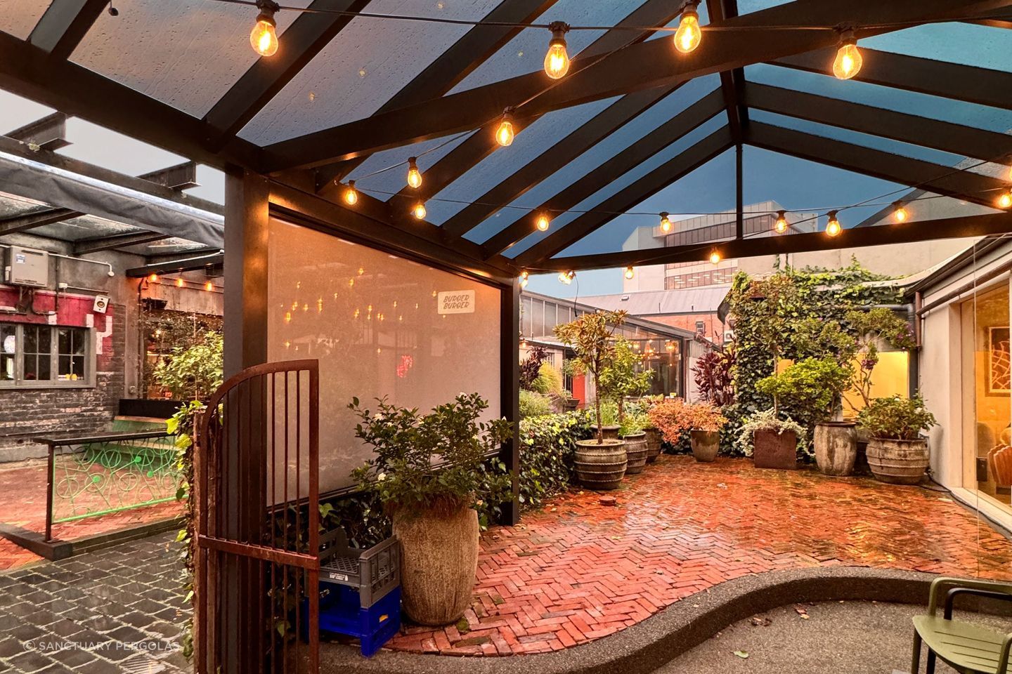 The acrylic roof on this pergola allows it to be used in any weather and the custom tinting gives protection from the sun.