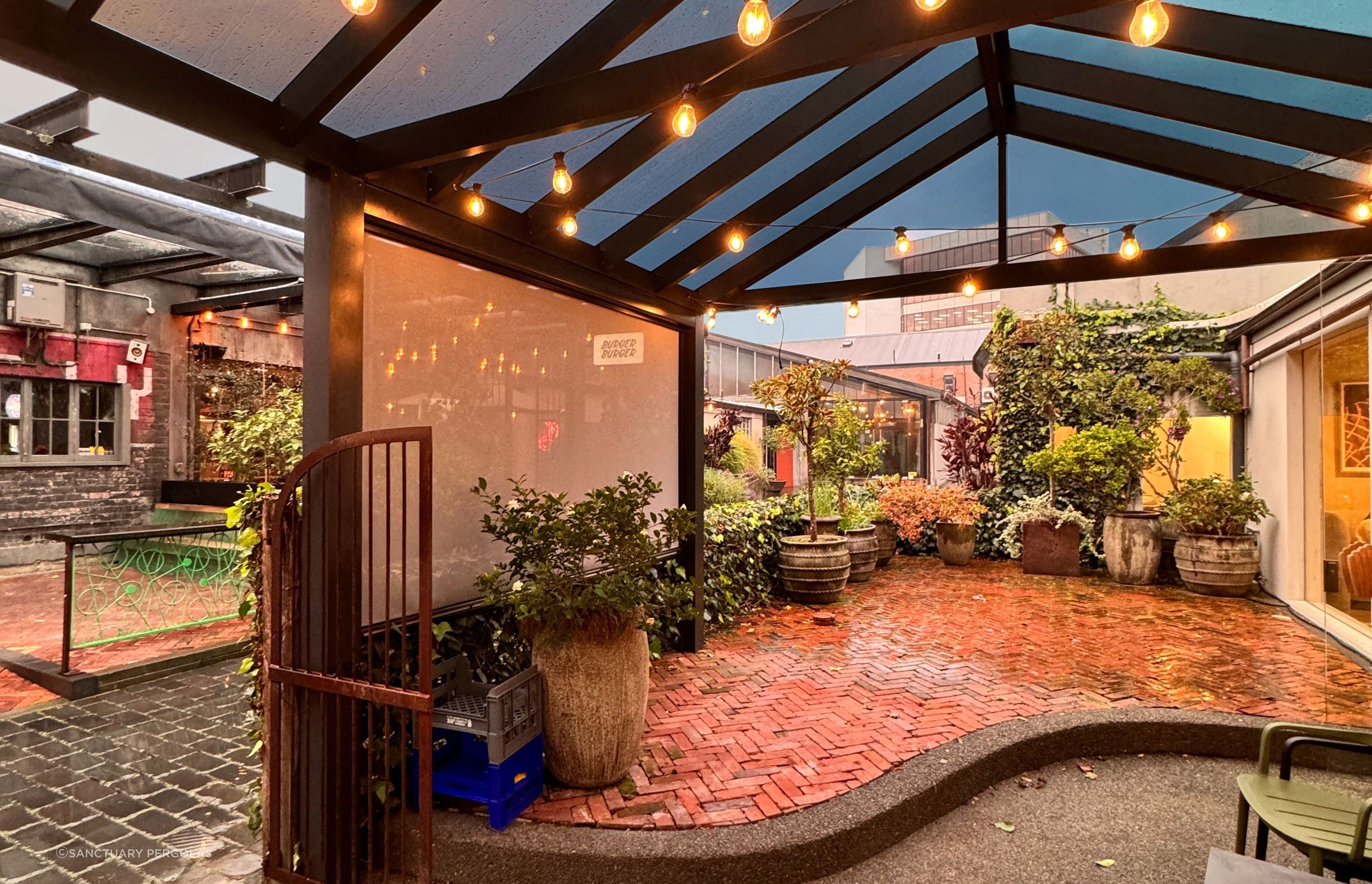 The acrylic roof on this pergola allows it to be used in any weather and the custom tinting gives protection from the sun.