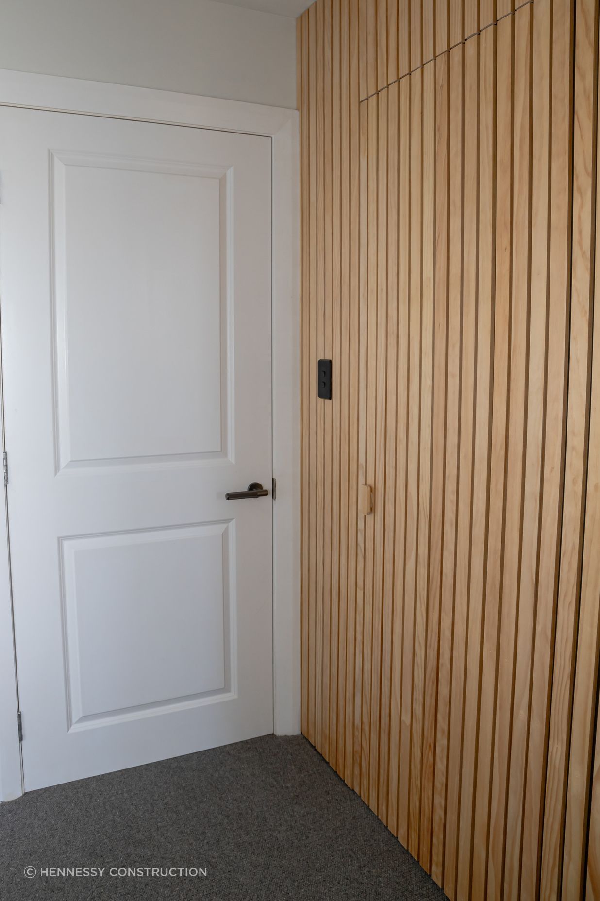 The timber batten wall conceals the doorway to the walk-in wardrobe and ensuite.