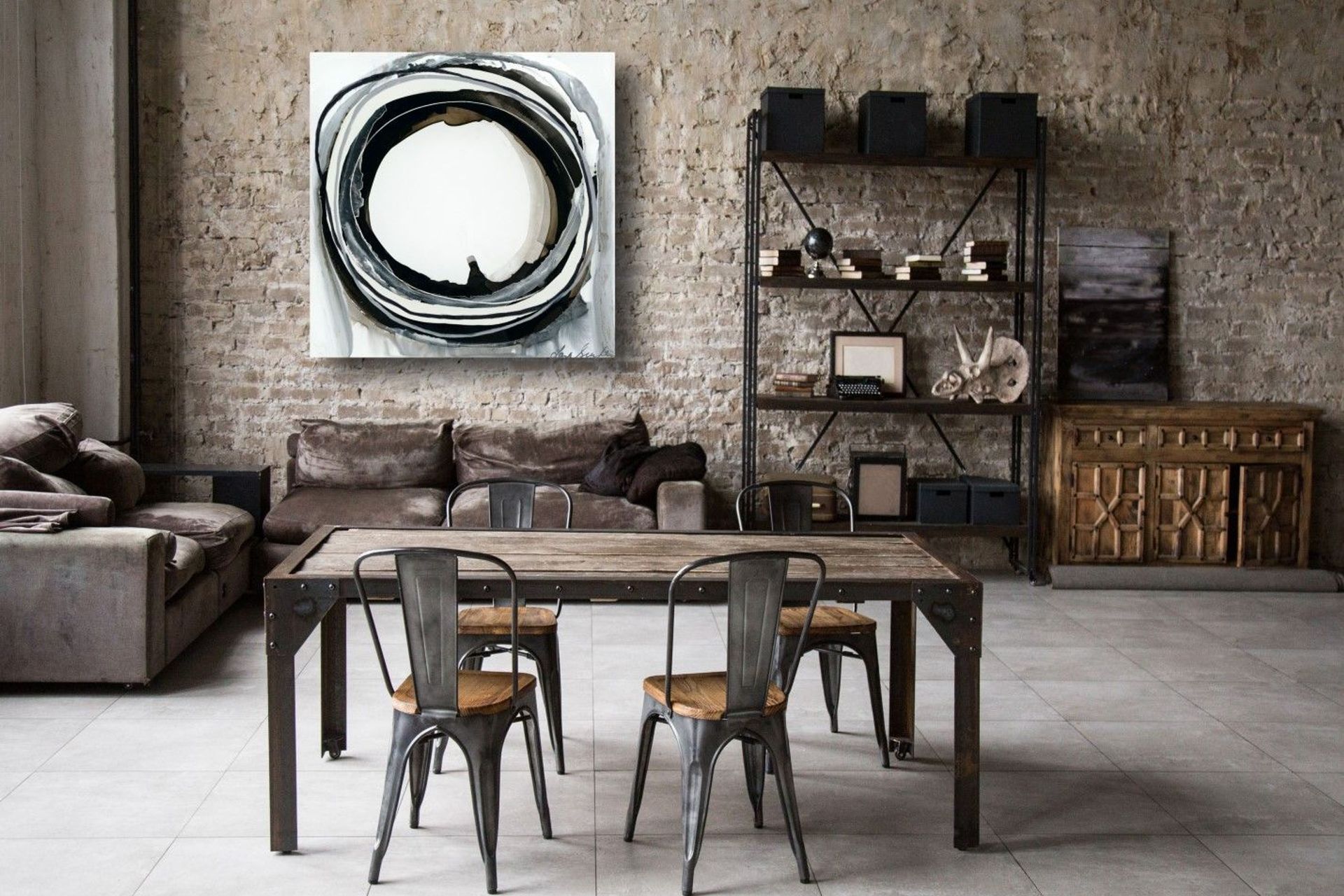 The wall art in this living space reflects the Industrial interior design style.