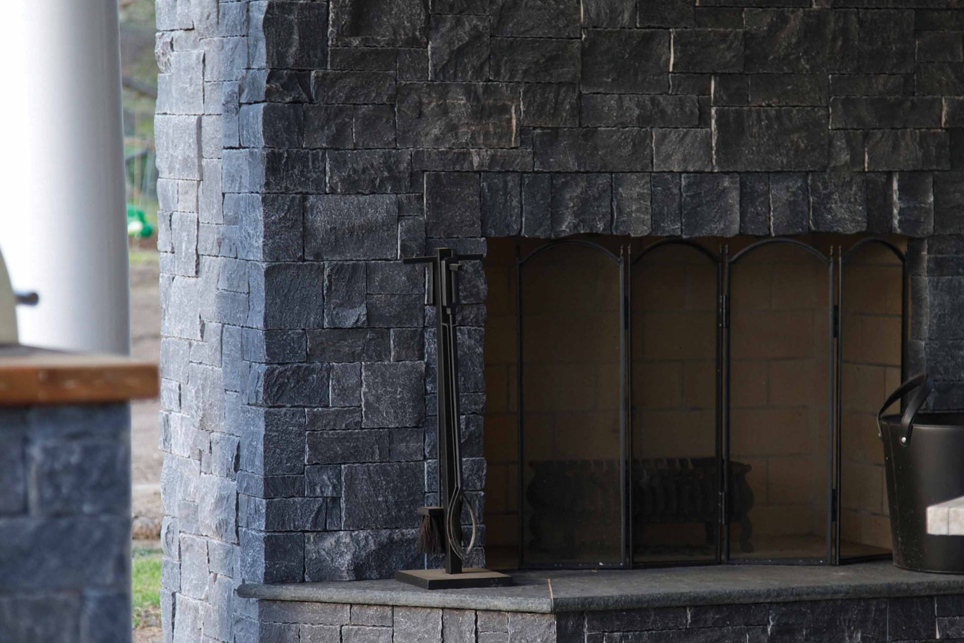 Noir modular stone wall cladding with its earthen charcoal appearance is a stunning cladding choice for a fireplace and the surrounding wall.