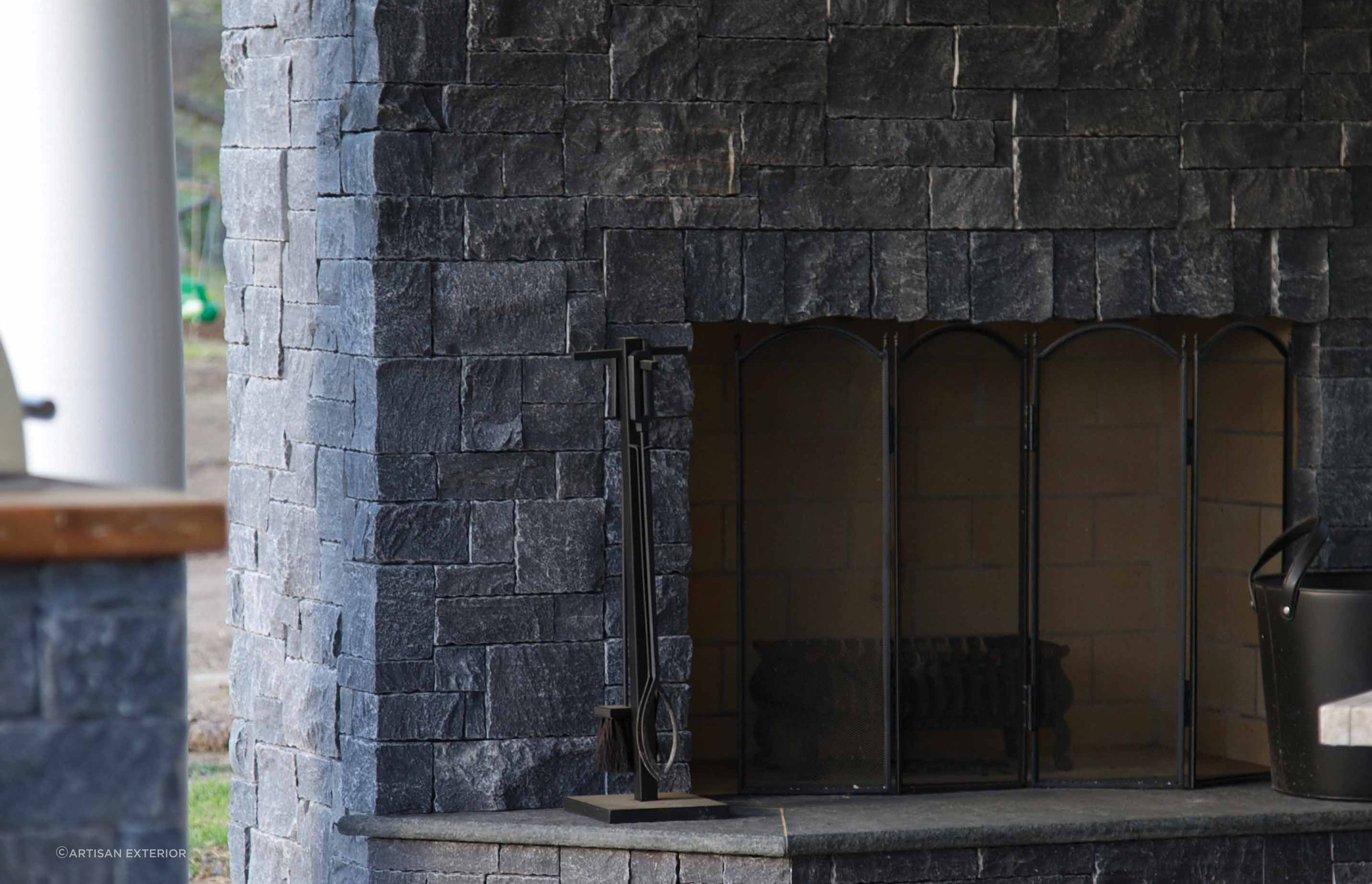 Noir modular stone wall cladding with its earthen charcoal appearance is a stunning cladding choice for a fireplace and the surrounding wall.