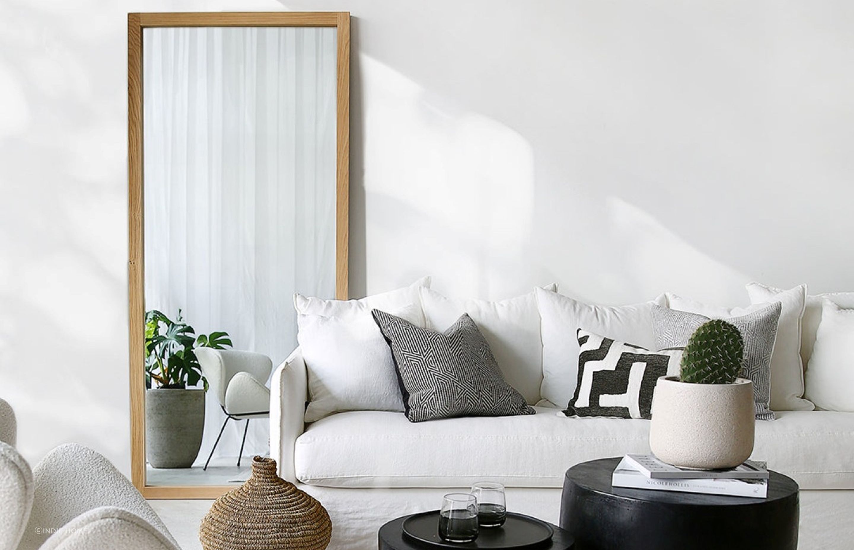 A strategically placed mirror, like this Oak Mirror from Indie Home, can enhance the sense of spaciousness.