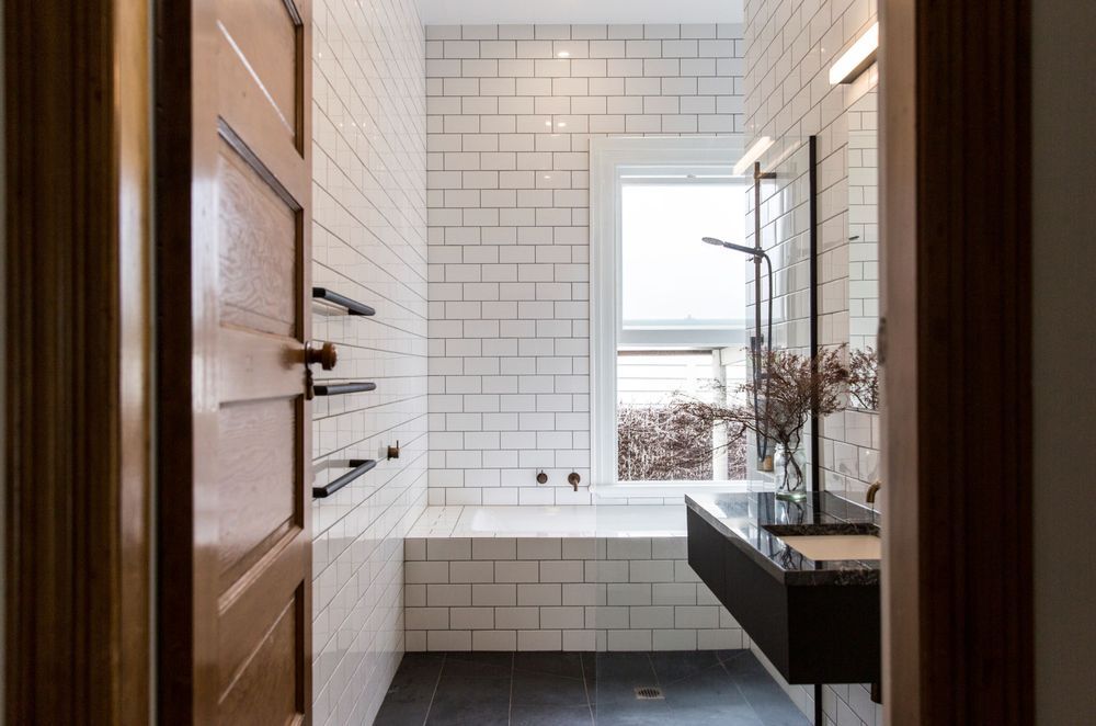 Floor-to-ceiling tiling, akin to that of a cosy wet room, showcases the best in contemporary bathroom styling in this Sandringham home.