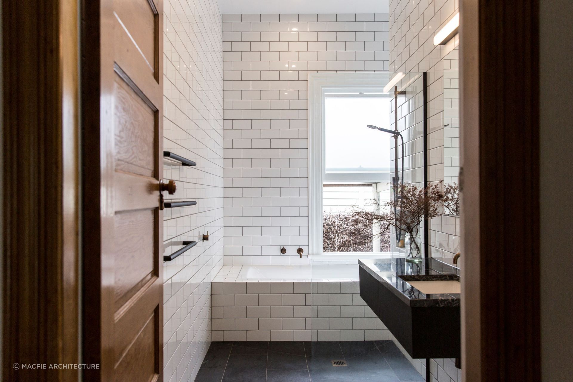 Floor-to-ceiling tiling, akin to that of a cosy wet room, showcases the best in contemporary bathroom styling in this Sandringham home.