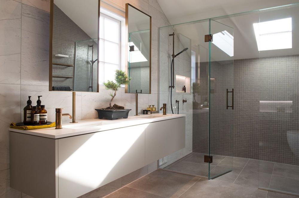 The beautiful bathroom renovation of Rangitoto House featuring vanity-mounted mirrors.