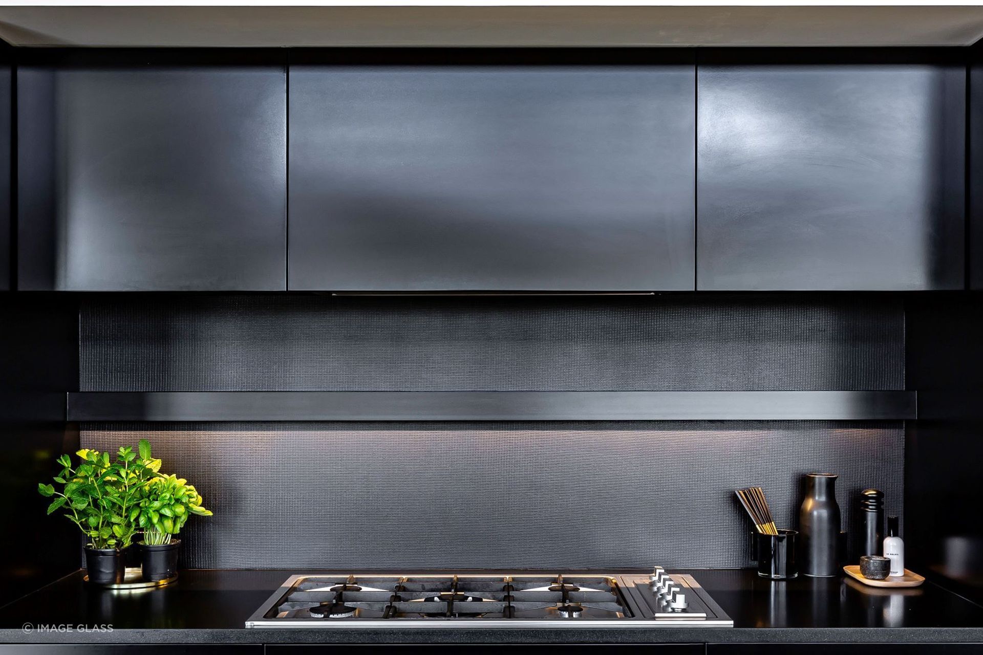 The metal coated glass splashback in this Remuera kitchen is bold, robust and contemporary.