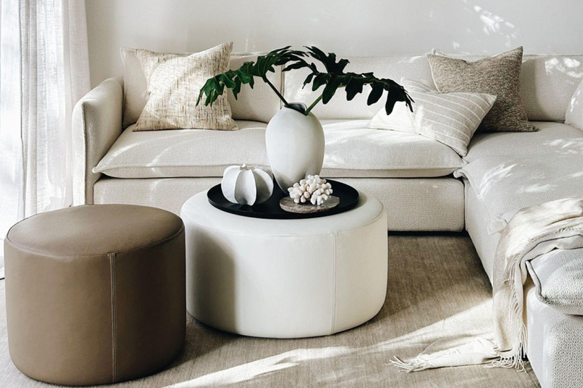 The 'Rio' Ottoman in Cream Leather from Indie Home sets a great stage for decorative pieces.
