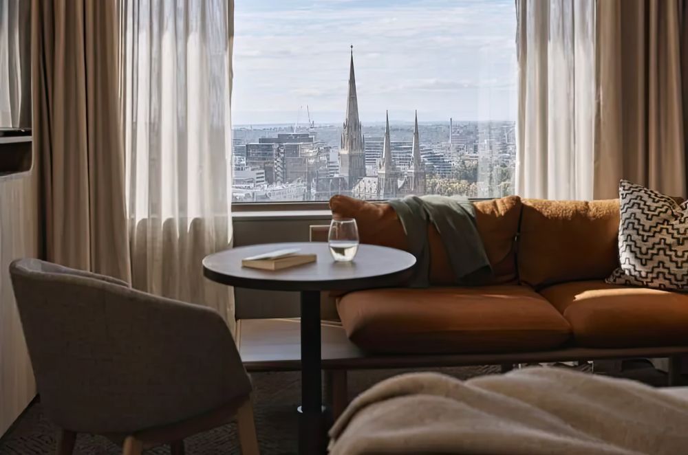 Layered window treatments featuring sheer and heavyweight curtains, seen at Rydges, Melbourne, designed to reflect light and block chilly winter drafts.