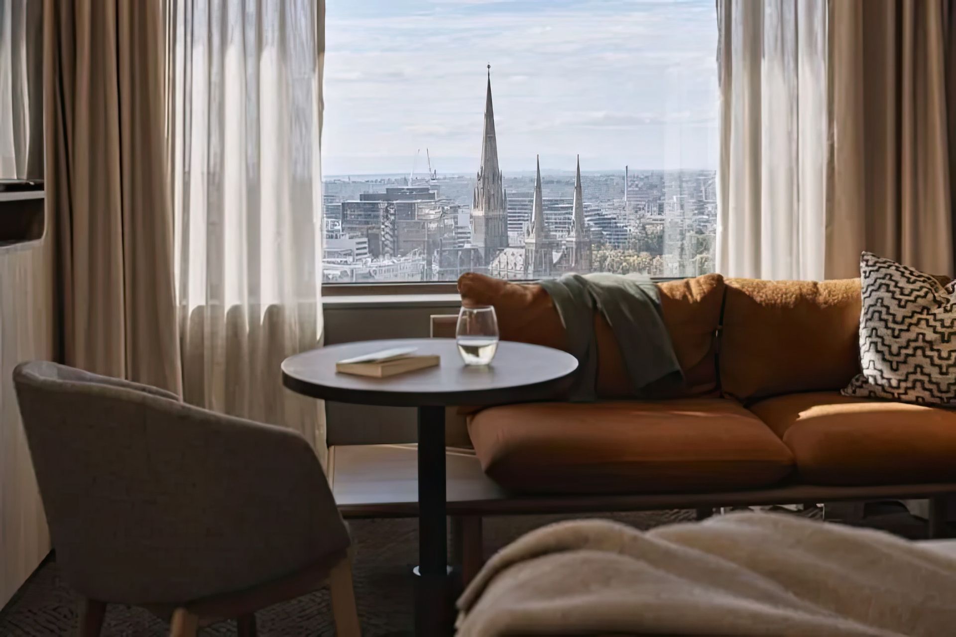 Layered window treatments featuring sheer and heavyweight curtains, seen at Rydges, Melbourne, designed to reflect light and block chilly winter drafts.
