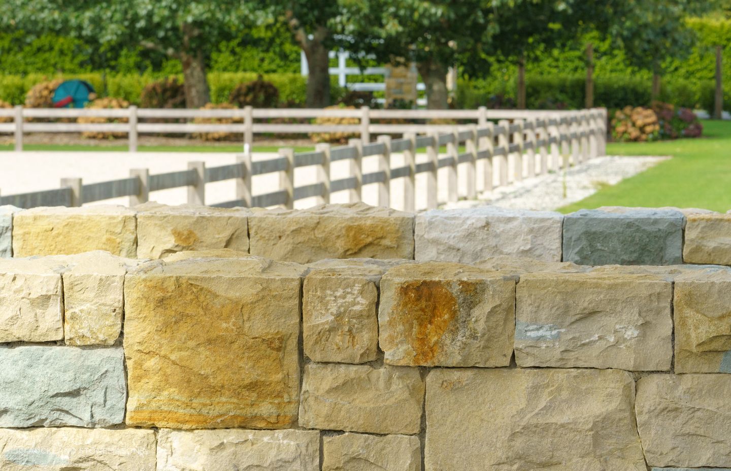 Stone boundary walls like this naturally add beautiful shades and textures to a property.
