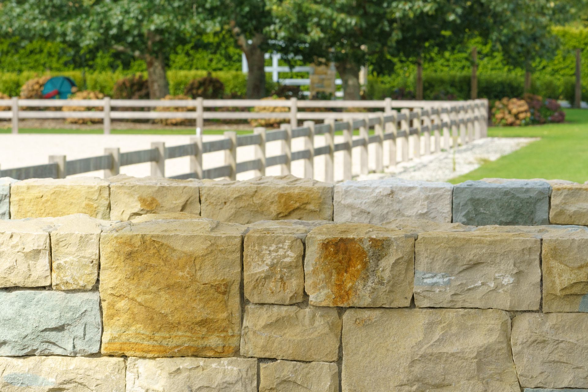 Stone boundary walls like this naturally add beautiful shades and textures to a property.