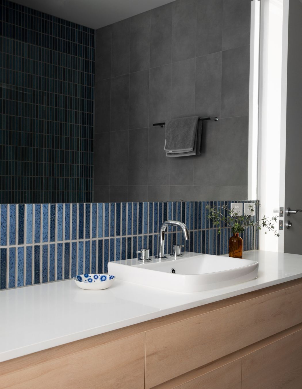 Tiles that incorporate different shades of blue are an easy way to bring a coastal theme to a bathroom.