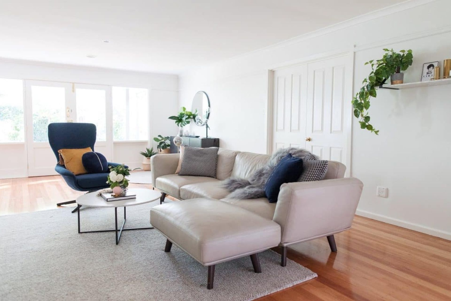 The blue cushions and armchair help this contemporary grey sofa stand out, while the design of the sofa compliments the natural wood tones of the flooring and rug nicely. Photography by Thorson photographer.