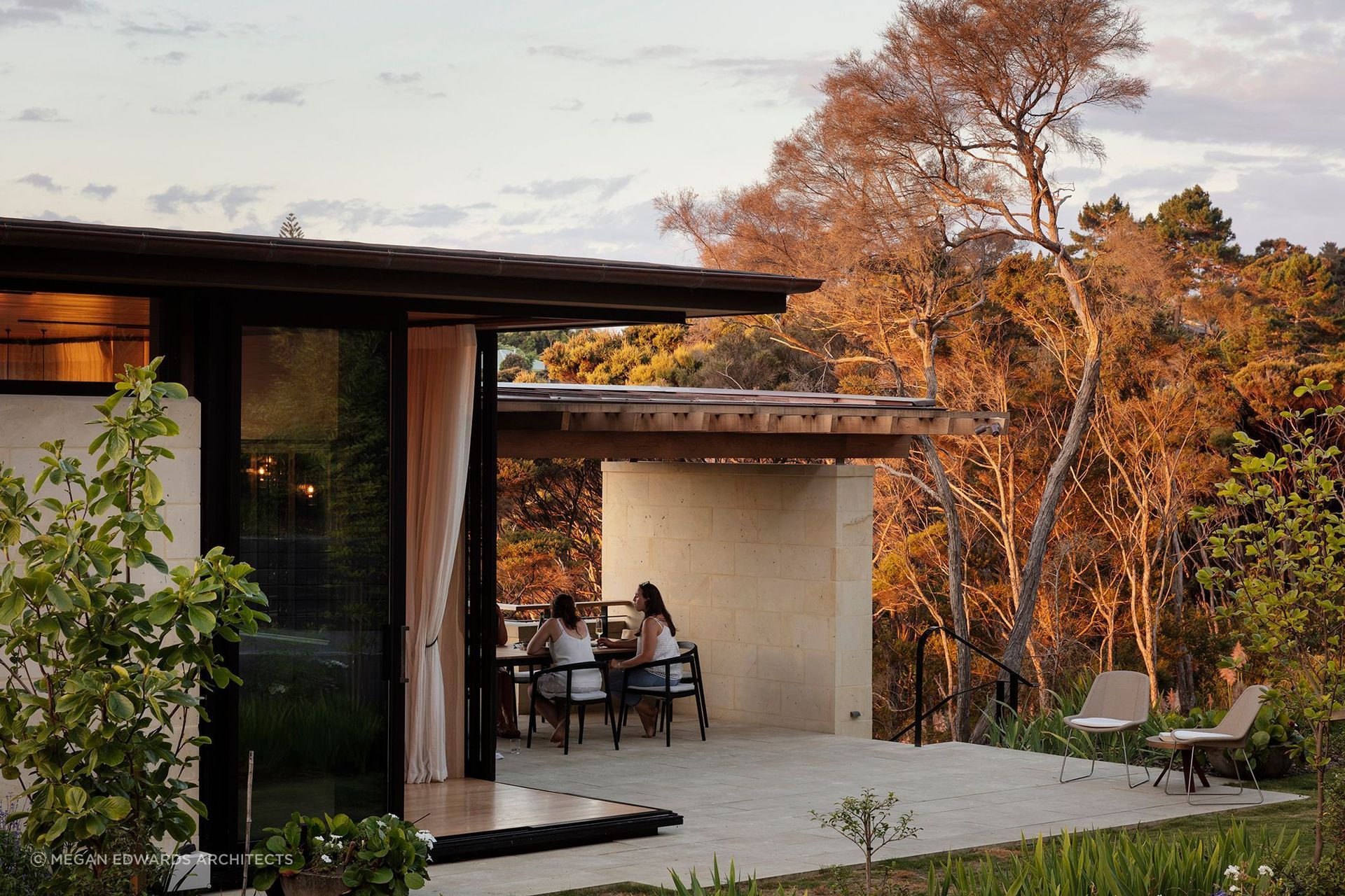 Megan Edwards Architects pairs a Hinuera Stone base with a light, glazed upper level, giving this Greenhithe home a refined modernist profile.