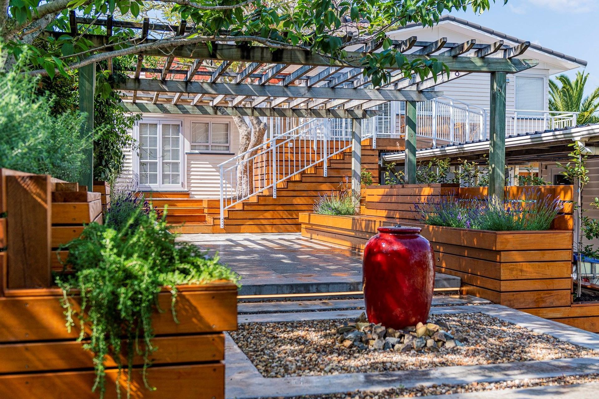 A water feature, like the one featured in this lovely home in Titirangi, can act as a strong focal point for an outdoor living space.