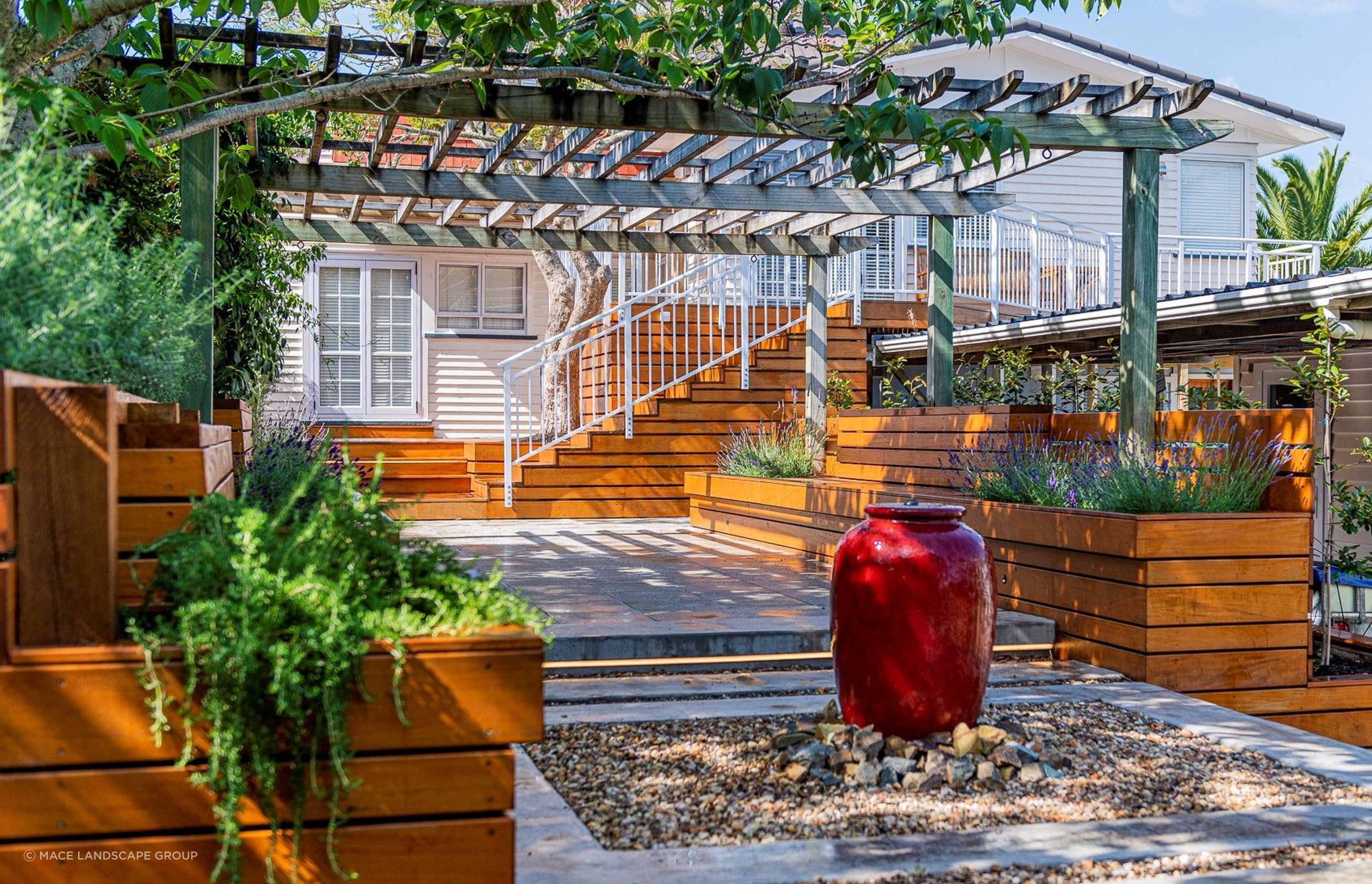 A water feature, like the one featured in this lovely home in Titirangi, can act as a strong focal point for an outdoor living space.