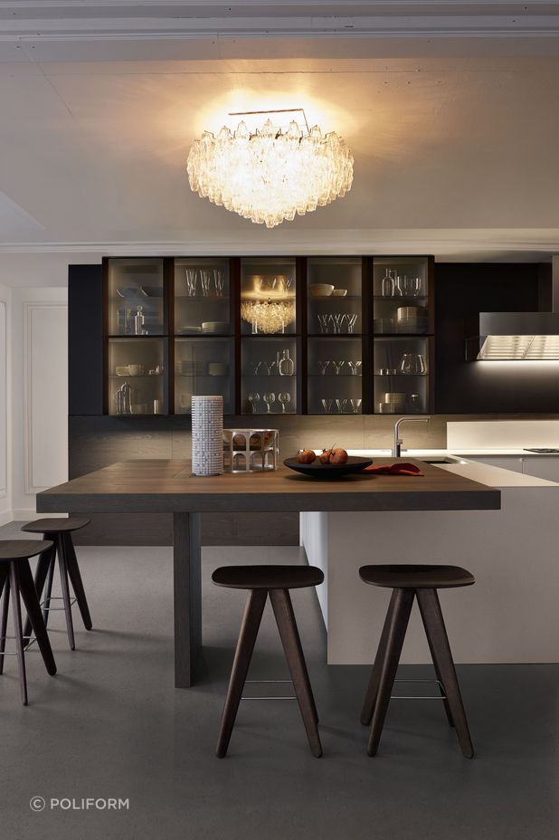 An elegant chandelier can act as a focal point in a modern kitchen. Featured product: Trail Kitchen