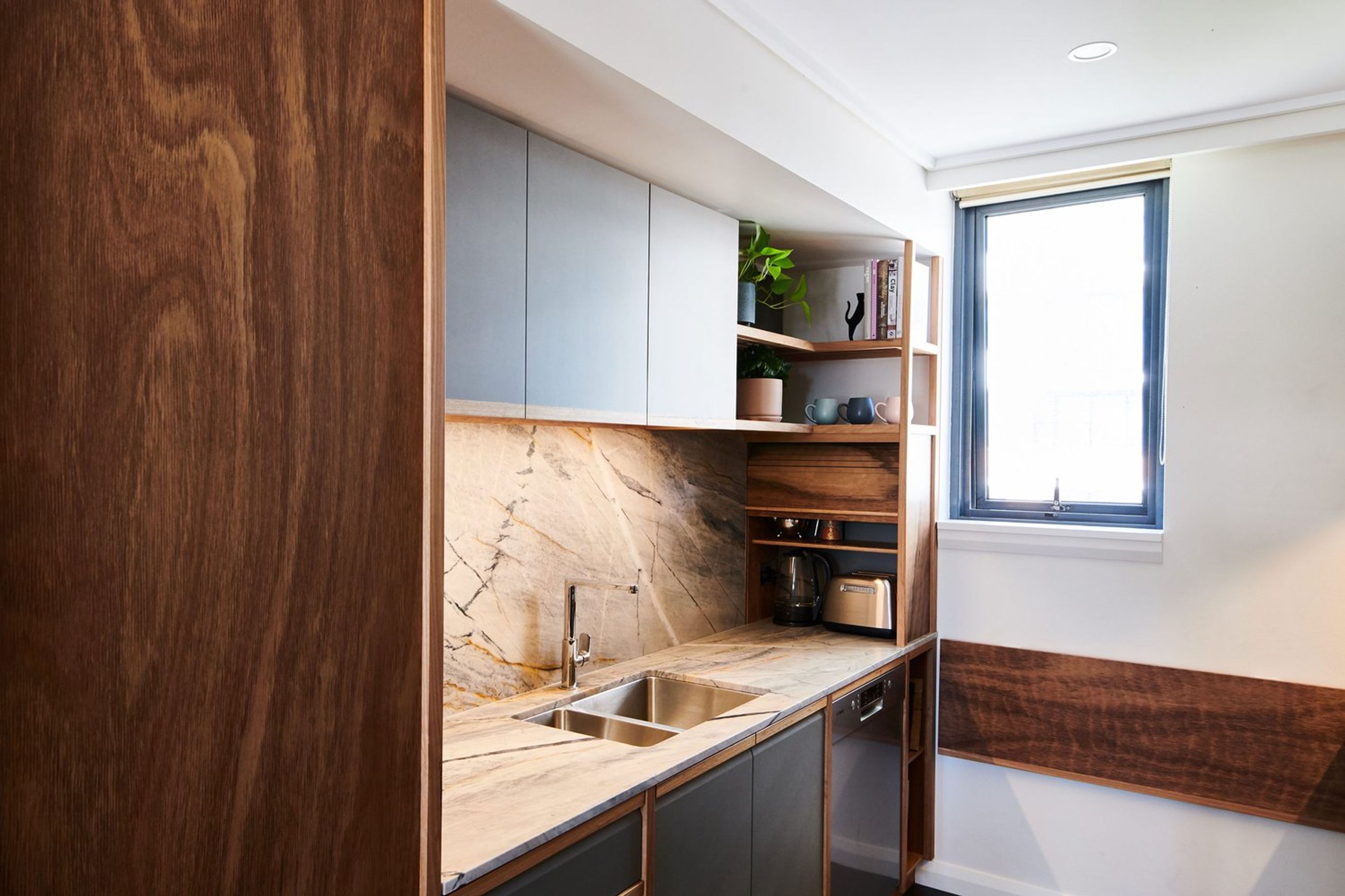 This neat Blackbutt tambour door is a perfect solution for this tidy kitchen in Prymont. | Photography: Joshua Morris