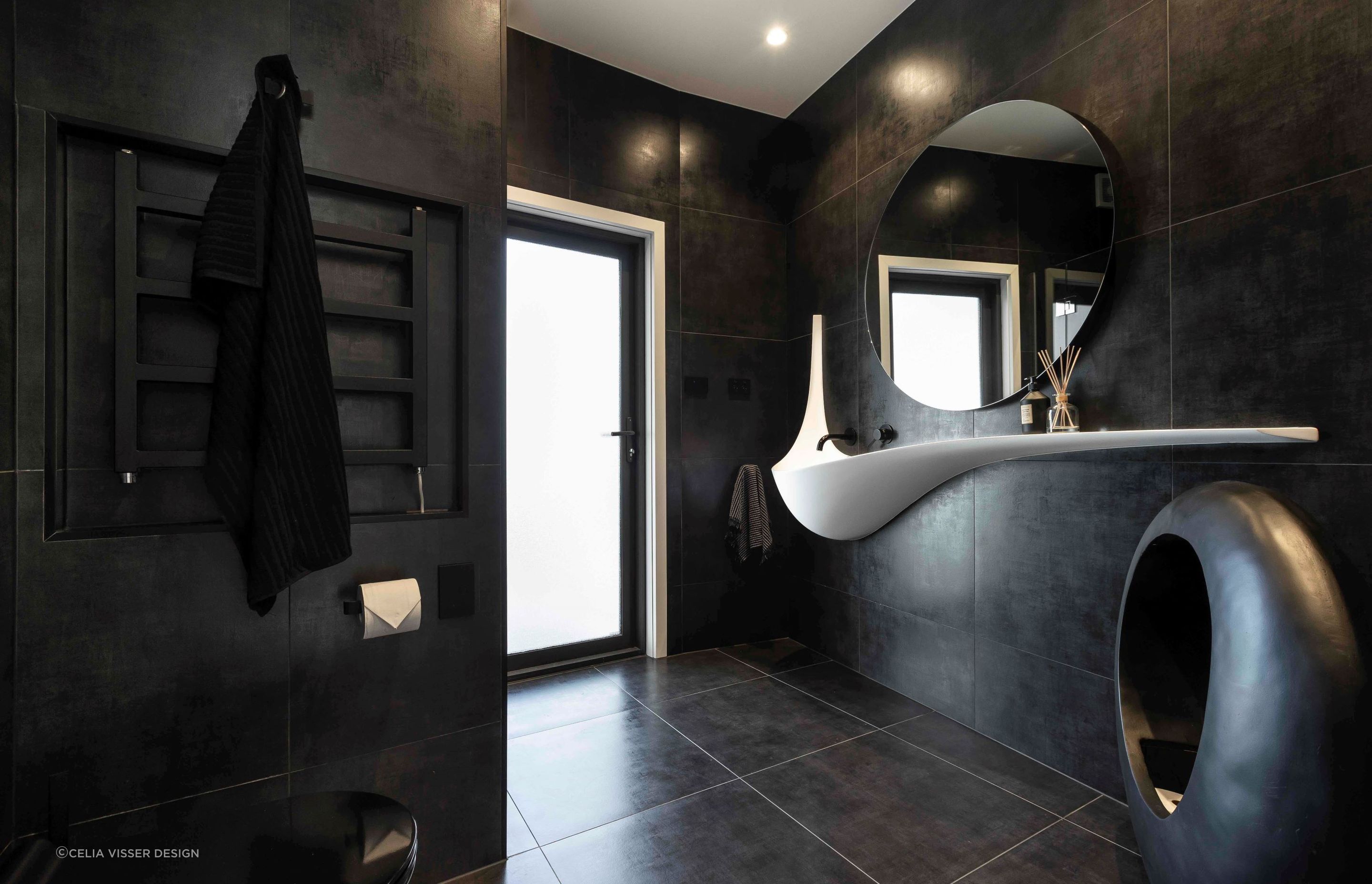 Modern bathroom designs, like this stylish black bathroom in Wiri, are much more daring with their colour schemes.