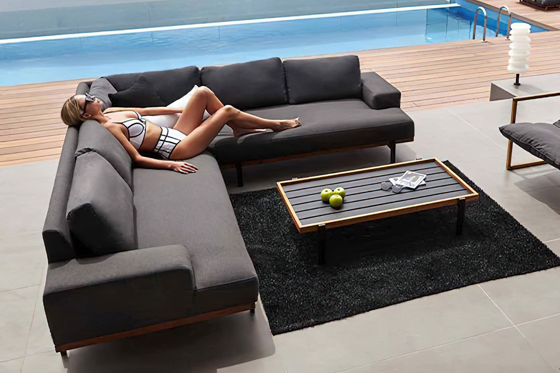 Woman-lounges-on-a-modern-dark-grey-l-shaped-outdoor-sofa-2.jpg
