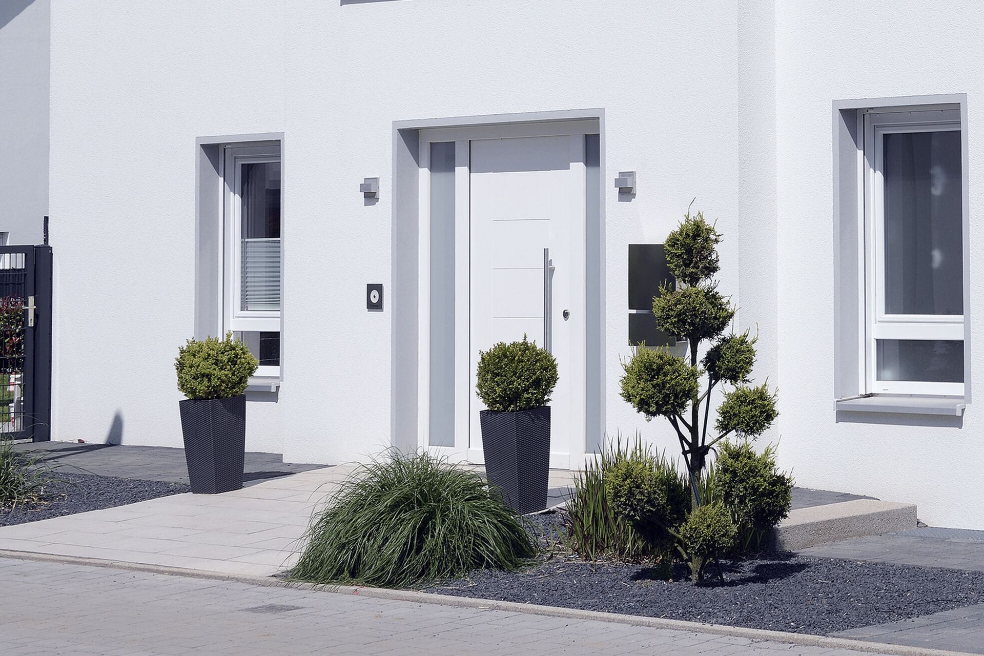 The pristine white PVC door, central to this home's facade, is not only visually appealing but also offers plenty of practical benefits.