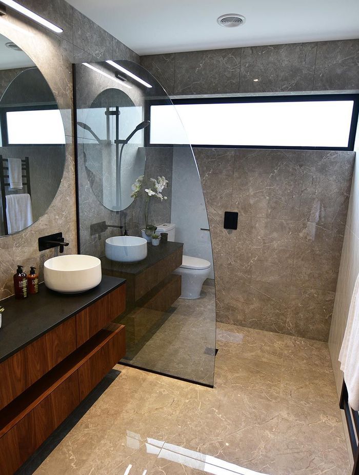 Tinted and curved, this glass shower screen adds a touch of personality to the bathroom.