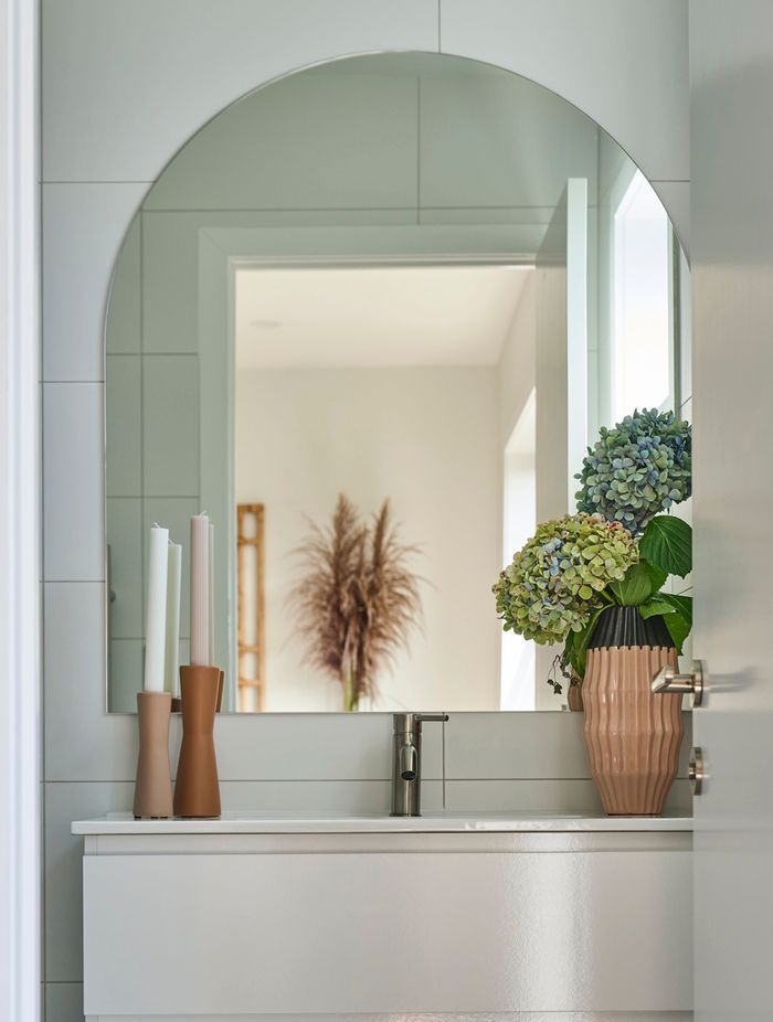 This custom arch mirror is the perfect addition to this small bathroom.