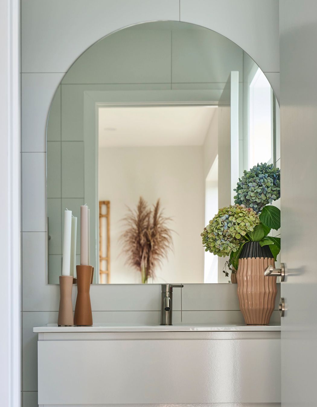 This custom arch mirror is the perfect addition to this small bathroom.