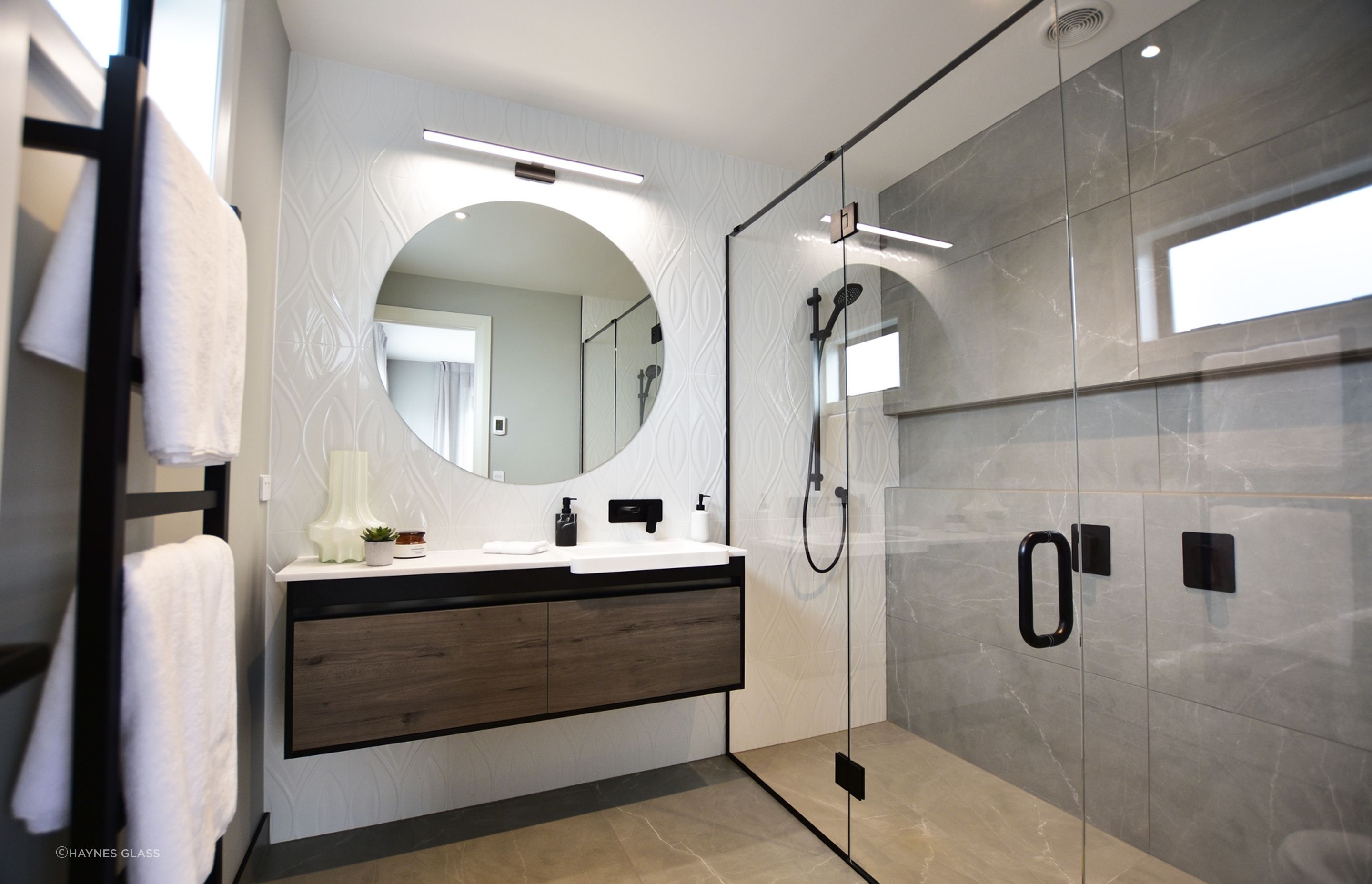 A large bathroom mirror, like the custom design by Haynes Glass, can enhance the feeling of spaciousness.