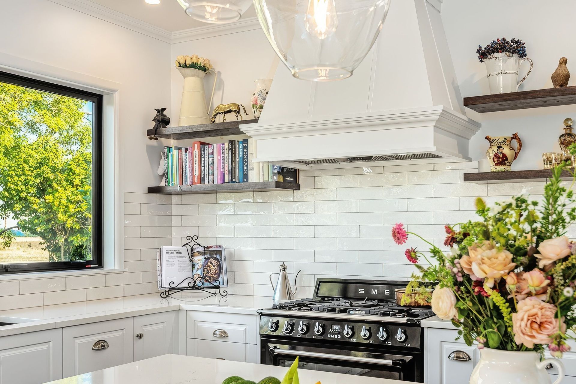 Wall shelving increases kitchen storage while providing the perfect space for an uninterrupted display of the homeowner's personal treasures and curated collection of recipe books.
