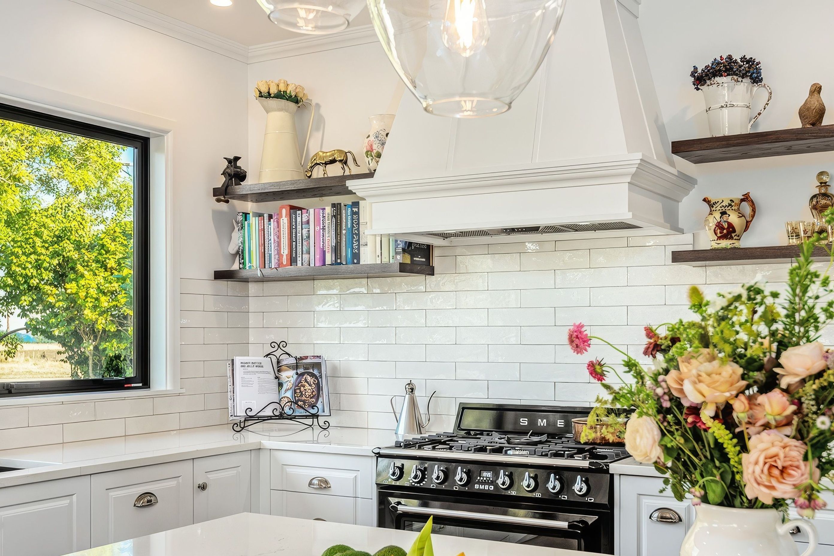 Wall shelving increases kitchen storage while providing the perfect space for an uninterrupted display of the homeowner's personal treasures and curated collection of recipe books.