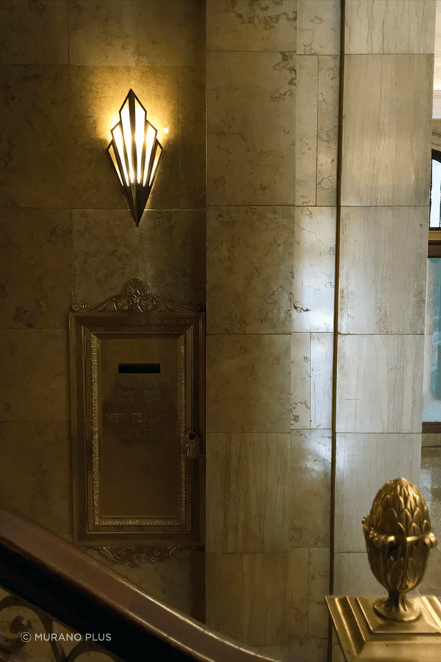 Custom-made Mikado wall fan-shaped wall lights in aged brass and alabaster are placed at considered intervals.