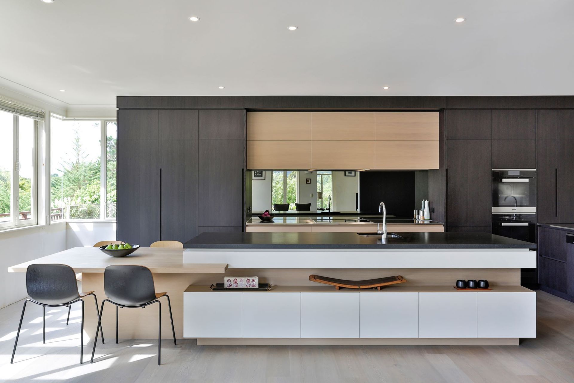 The mirrored splashback in this stunning kitchen in Matakana creates a wonderful illusion of space — Photography: Jamie Cobel