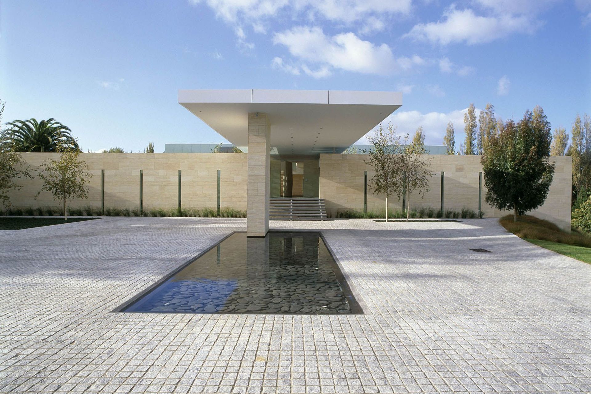 The warm earthy tones of Niwala Spanish Sandstone Cladding, matched perfectly here with granite cobblestones.