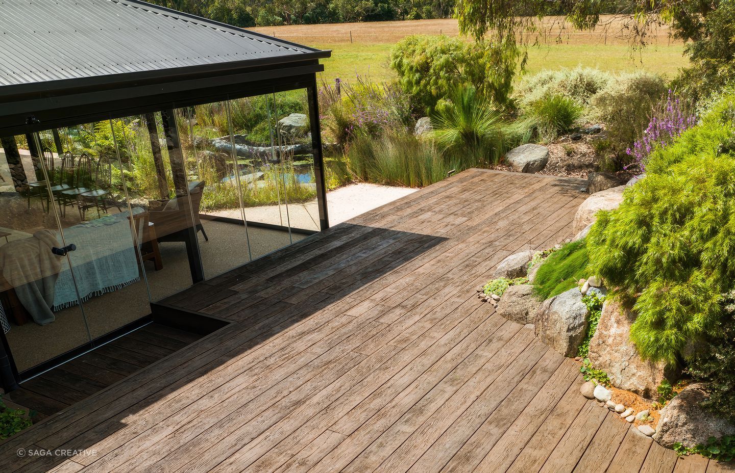 "This incredible garden was designed by award winning landscape designer and horticulturist Phillip Johnson, a winner of the prestigious Chelsea Flower &amp; Garden Show, Best in Show Award. With tranquility and sustainability in mind, the Millboard Vintage Oak decking seamlessly complements the surrounding Native Australian planting."