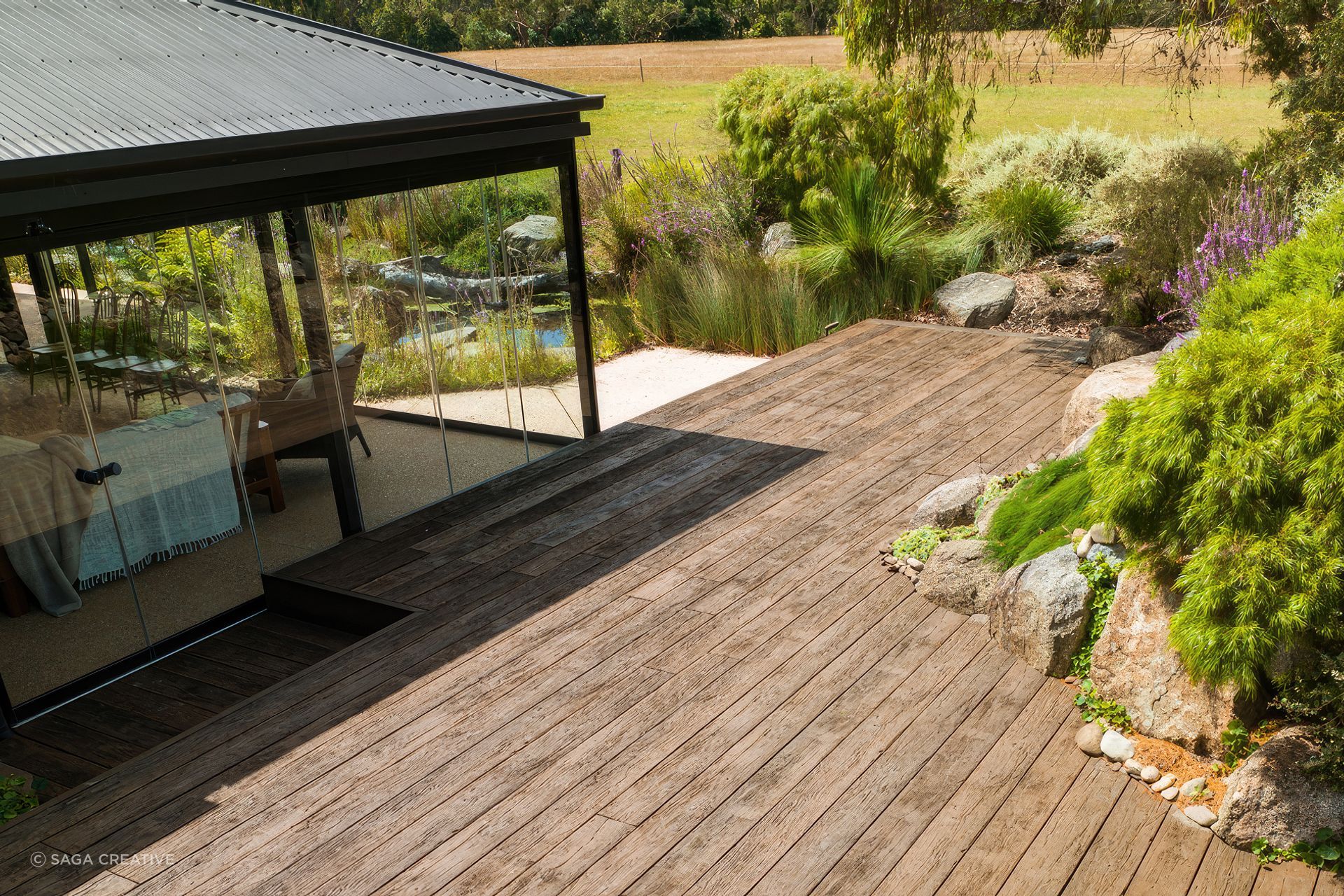 "This incredible garden was designed by award winning landscape designer and horticulturist Phillip Johnson, a winner of the prestigious Chelsea Flower &amp; Garden Show, Best in Show Award. With tranquility and sustainability in mind, the Millboard Vintage Oak decking seamlessly complements the surrounding Native Australian planting."
