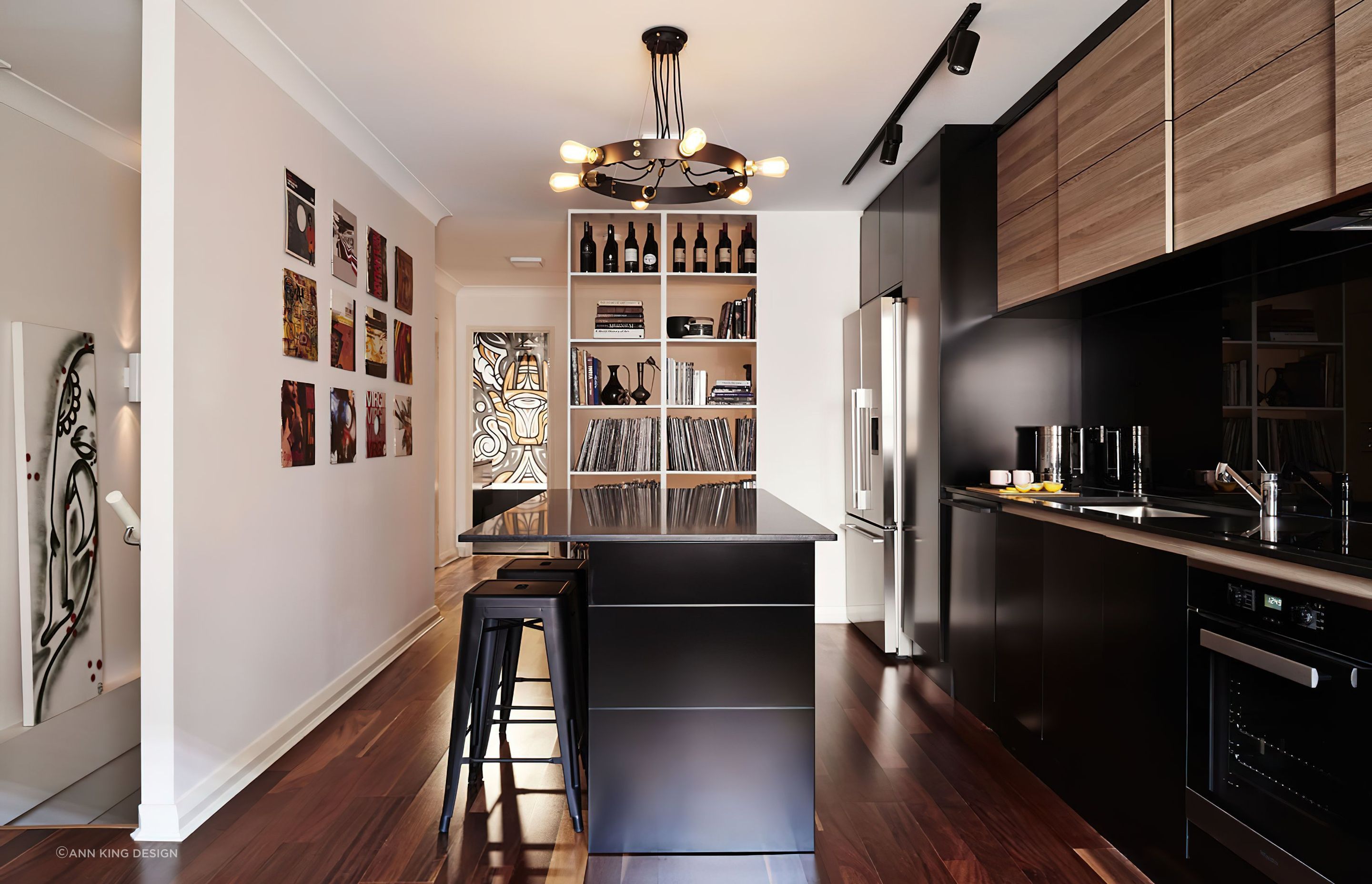 The lighting fixture in this kitchen matches the worktop style and compliments the wall art and record sleeves placed on the wall.