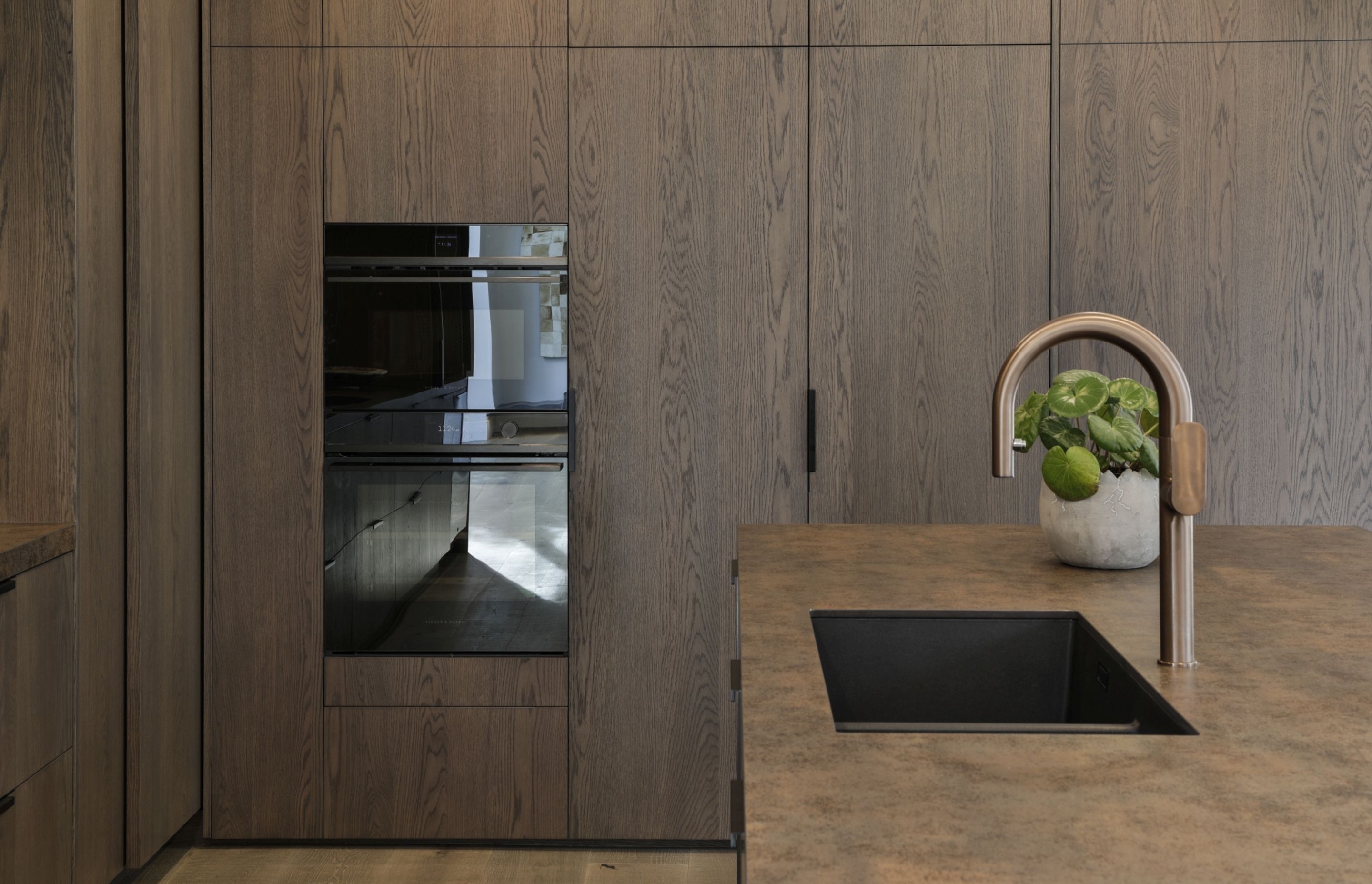 American white oak veneer was chosen for this kitchen project as its pronounced grain adds a rustic touch to the sleek space.