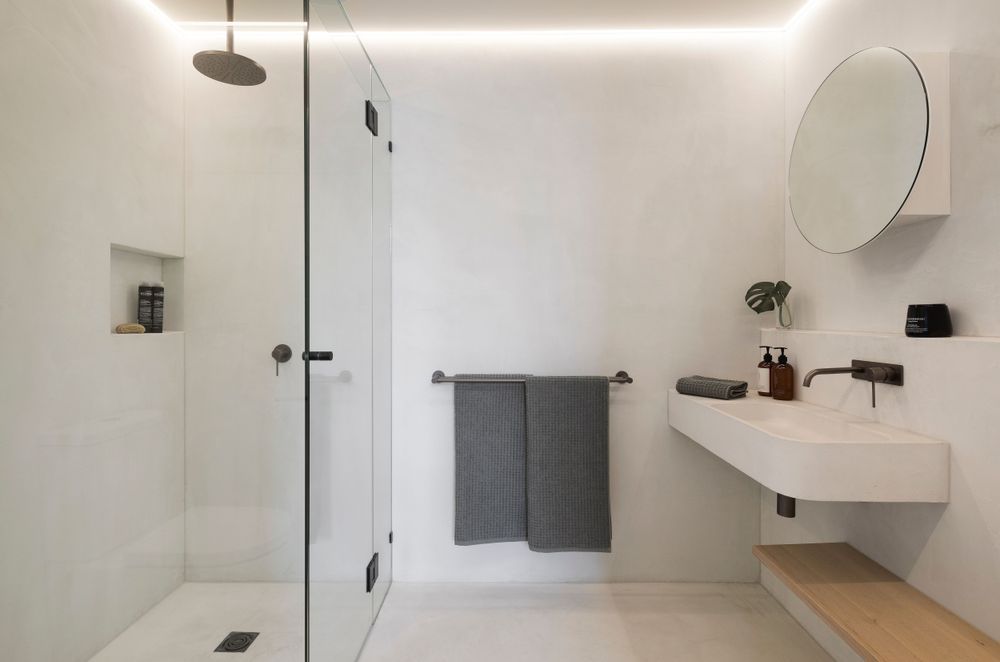 Strip lighting illuminates a minimalist bathroom at King St Townhouse | Photography: Dylan James Photo