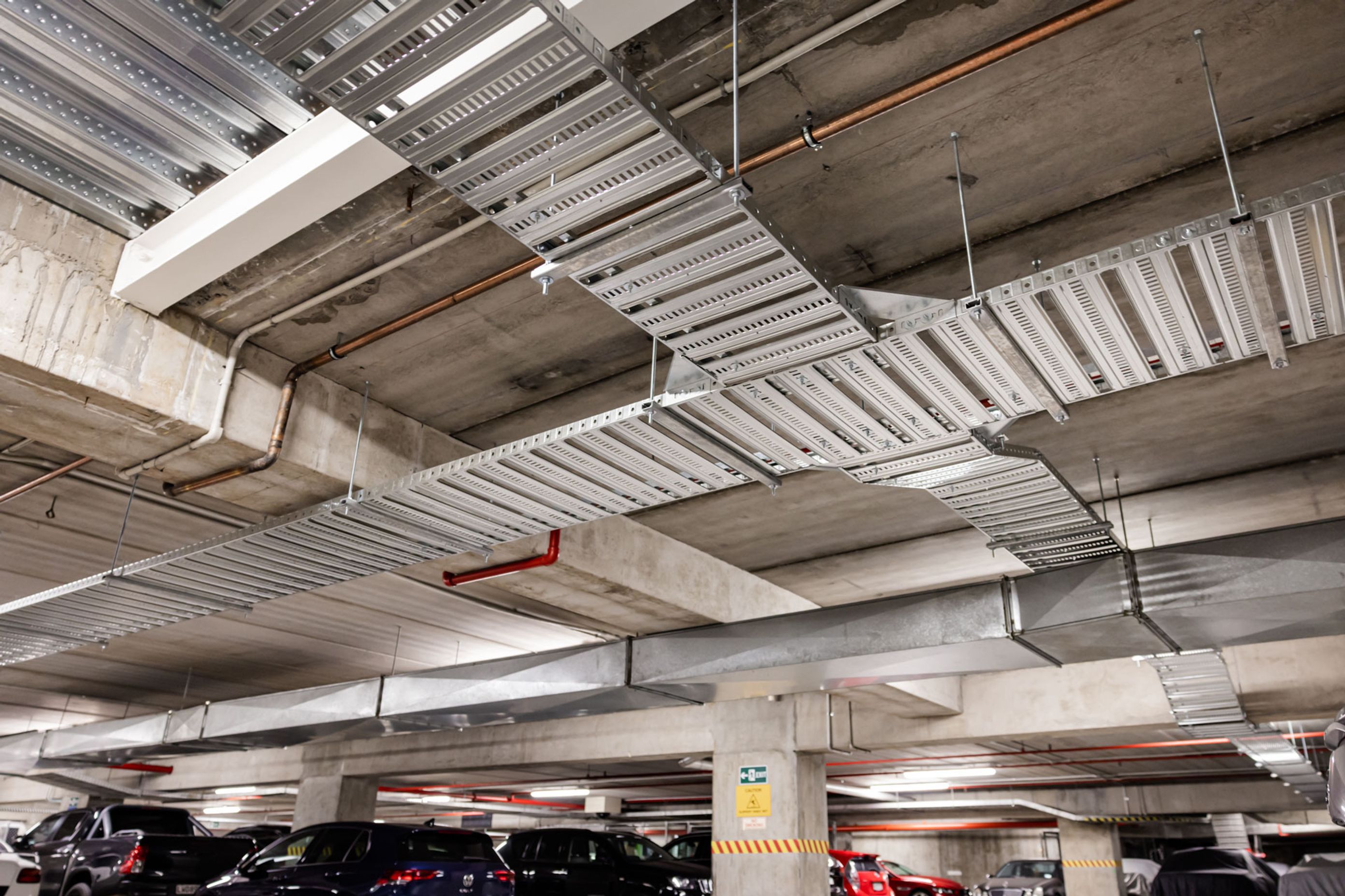 Dedicated cable trays are installed to distribute the EV charger cables throughout the carpark.