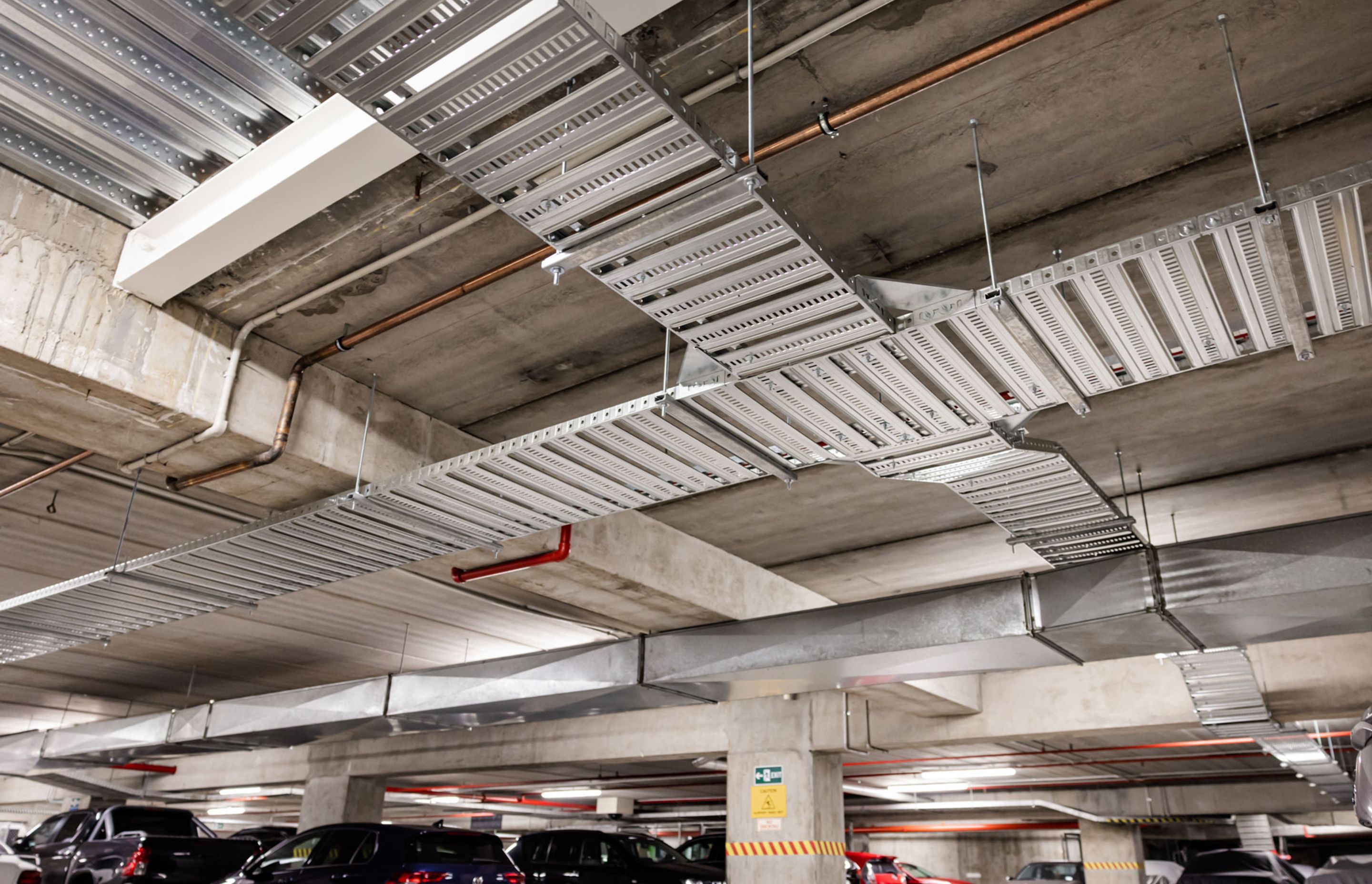 Dedicated cable trays are installed to distribute the EV charger cables throughout the carpark.