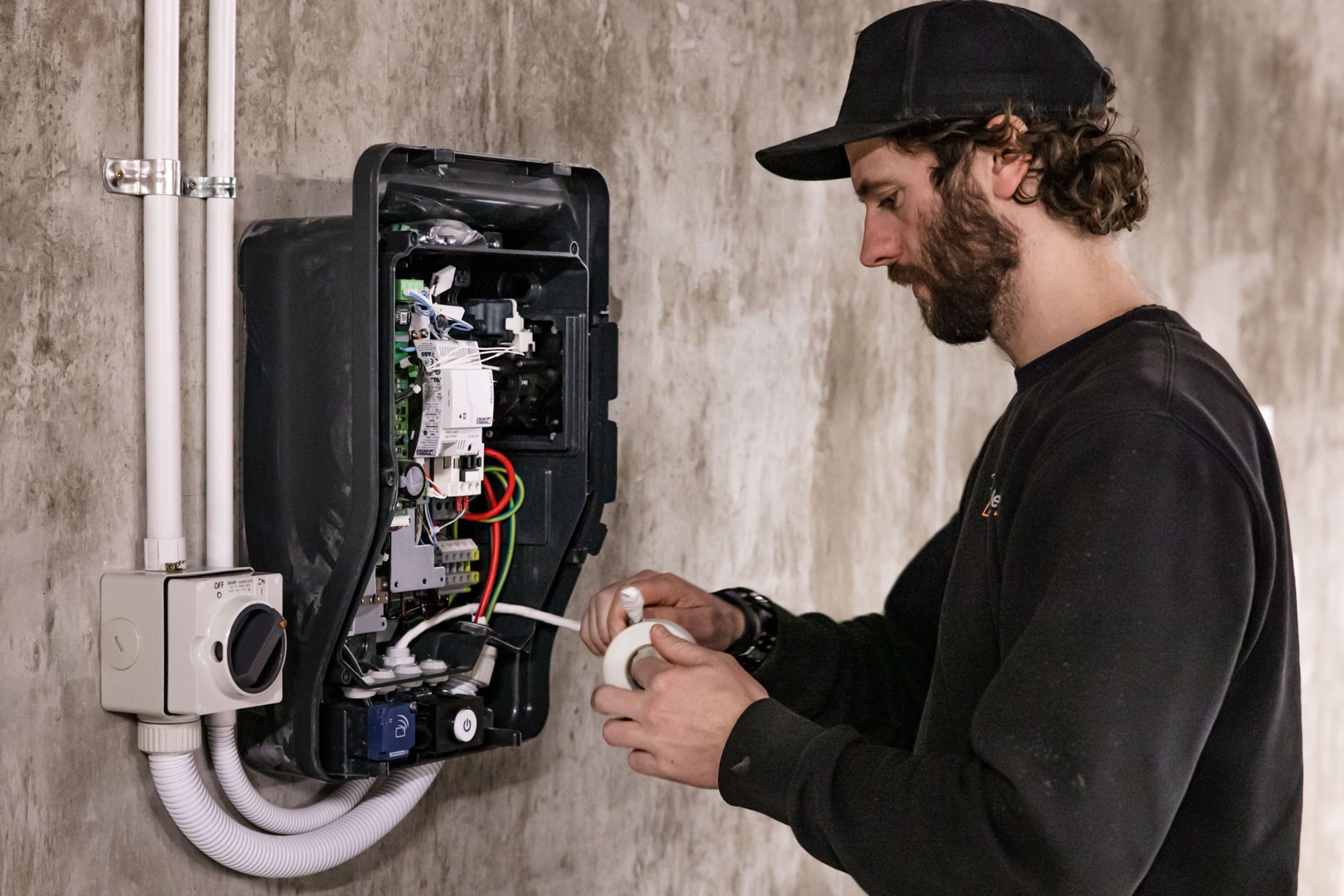 A K C Electrics team member is midway through the EV charger installation process.
