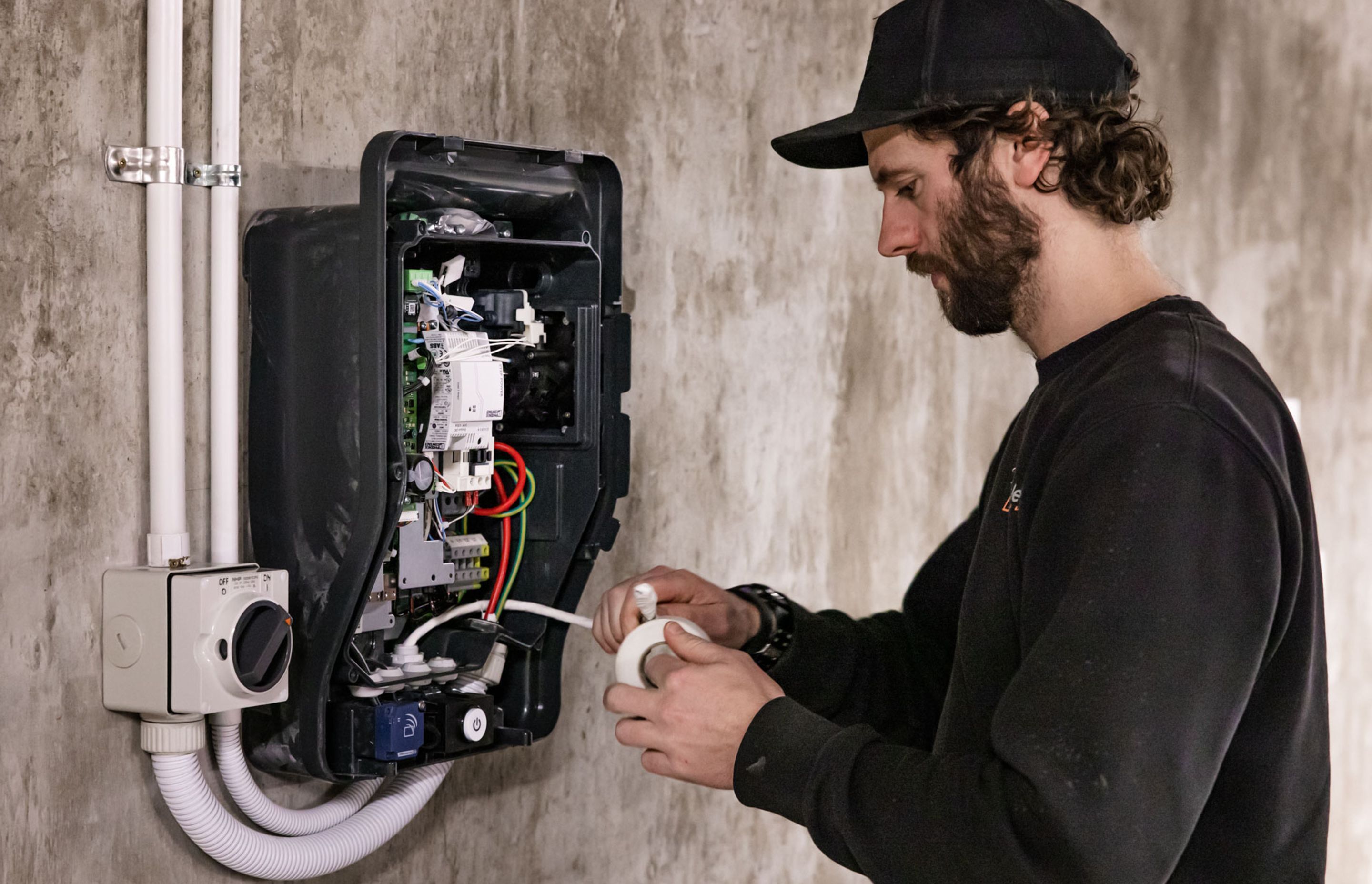 A K C Electrics team member is midway through the EV charger installation process.