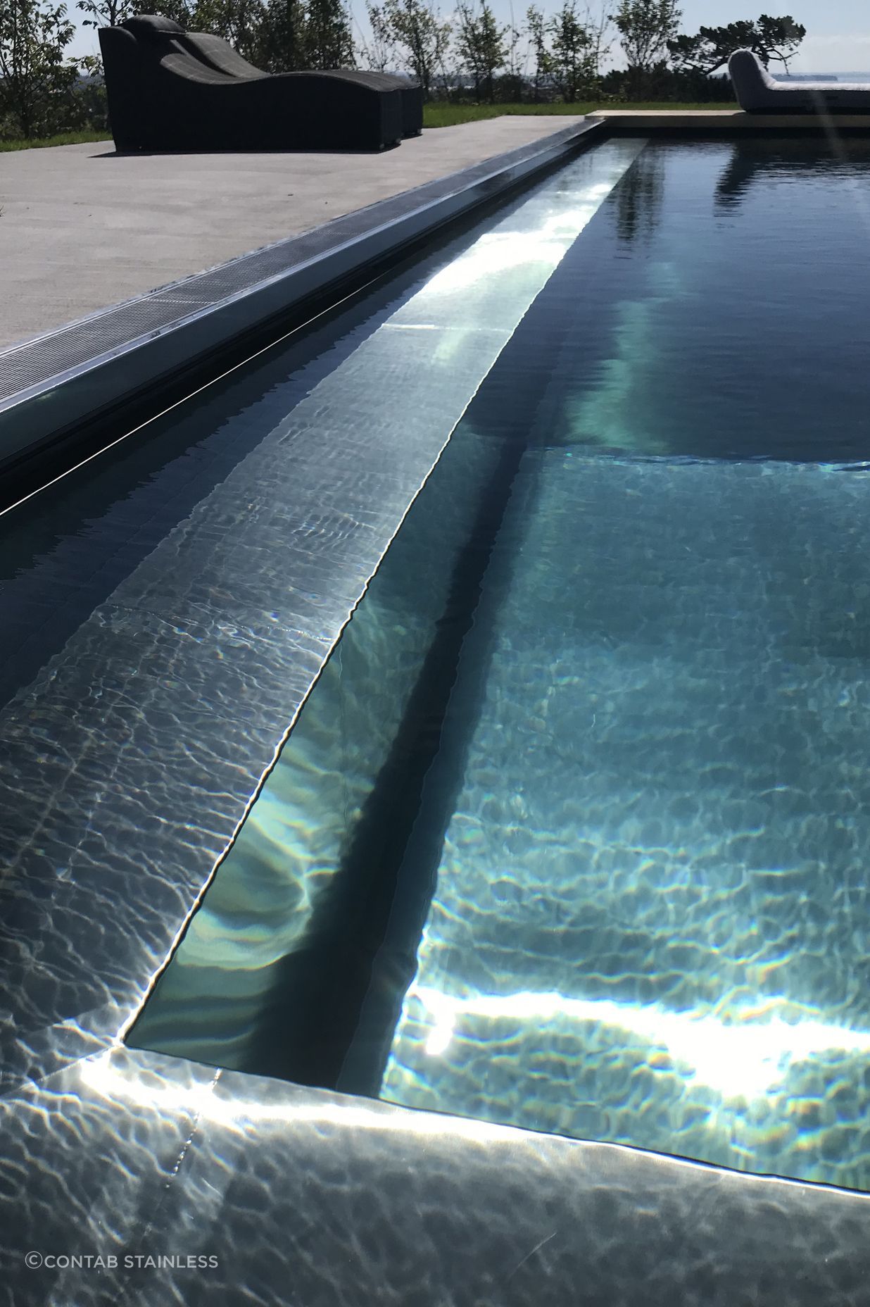 The custom-made stainless steel pool glistens in the sun.