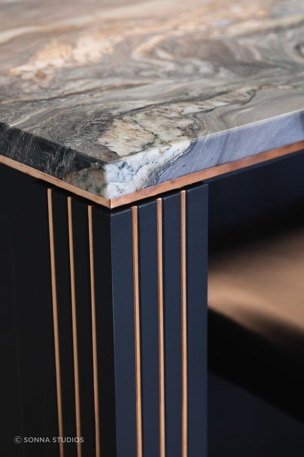 "A live-finish copper detail was introduced to add drama to the material palette; as the copper naturally patinas it will blend with the stone to create an ever-changing kitchen."